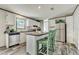 Modern kitchen with stainless steel appliances, white cabinetry, and a breakfast bar area at 892 Se 124Th Ave, Webster, FL 33597