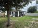 Spacious backyard with covered patio, playhouse, mature tree, and privacy fence at 9219 Chandler Dr, Groveland, FL 34736