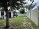 Spacious backyard with covered patio, mature tree, and privacy fence at 9219 Chandler Dr, Groveland, FL 34736