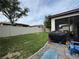 Fenced backyard featuring a covered patio area with grilling equipment and outdoor seating, perfect for entertaining at 9219 Chandler Dr, Groveland, FL 34736
