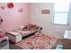 Charming ' bedroom with a pink accent wall, cozy bed with stuffed animals, and a delightful floral rug at 9219 Chandler Dr, Groveland, FL 34736