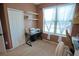 Cozy bedroom featuring a sewing station, bright natural light from the large window, and neutral walls at 9219 Chandler Dr, Groveland, FL 34736