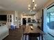 Open-concept dining area with modern lighting fixtures and views of the kitchen at 9219 Chandler Dr, Groveland, FL 34736