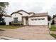 Charming single-Gathering home features a two-car garage, brick-paved driveway and manicured landscaping, creating a welcoming entry at 9219 Chandler Dr, Groveland, FL 34736