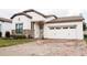 Charming single-Gathering home featuring a two-car garage and a brick-paved driveway at 9219 Chandler Dr, Groveland, FL 34736