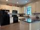 Bright kitchen with white cabinets, black appliances, and a sleek island at 9219 Chandler Dr, Groveland, FL 34736