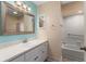 Bright bathroom with sink vanity, large mirror and shower with tub at 9499 Se 174Th Loop, Summerfield, FL 34491