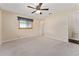 Neutral bedroom with carpet, ceiling fan, window, and closet at 9499 Se 174Th Loop, Summerfield, FL 34491