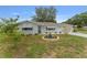 Welcoming single-story home with a lush lawn, vibrant flower beds, and a well-manicured garden at 9499 Se 174Th Loop, Summerfield, FL 34491