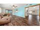 An open living room with hard wood flooring, and a look through to a sun room at 9499 Se 174Th Loop, Summerfield, FL 34491
