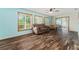 Open living room features wood floors, three windows, and a foosball table at 9499 Se 174Th Loop, Summerfield, FL 34491