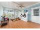 Enclosed sunroom features vinyl floors, ceiling fan, and laundry machines at 9499 Se 174Th Loop, Summerfield, FL 34491