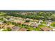 Aerial view of a neighborhood with lush landscaping, pond, and golf course at 9588 Se 124Th Loop, Summerfield, FL 34491