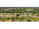 Aerial view of a neighborhood with lush landscaping, pond, and golf course at 9588 Se 124Th Loop, Summerfield, FL 34491
