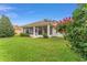 A gorgeous backyard with a manicured lawn leading up to the screened lanai at 9588 Se 124Th Loop, Summerfield, FL 34491