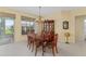 Dining room with wood table and chairs, chandelier, and view of the landscaped yard at 9588 Se 124Th Loop, Summerfield, FL 34491