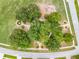 The aerial view of the community shows a park surrounded by mature trees and walking paths at 965 Dartmouth Ave, Clermont, FL 34711