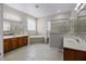 Bright bathroom with a corner tub, glass shower, double vanity, and large window at 965 Dartmouth Ave, Clermont, FL 34711