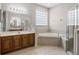 Well-lit bathroom with a soaking tub, glass-enclosed shower, and double vanity at 965 Dartmouth Ave, Clermont, FL 34711