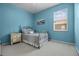 Serene bedroom with a blue accent wall, comfortable bed, and natural light at 965 Dartmouth Ave, Clermont, FL 34711