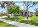 Well-maintained front yard with manicured lawn and mature trees adds curb appeal to this lovely home at 965 Dartmouth Ave, Clermont, FL 34711