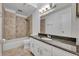 Bathroom featuring a single granite vanity, tiled shower-tub and modern fixtures at 102 Lake Emma Cove Dr # 102, Lake Mary, FL 32746