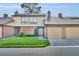 Charming townhome featuring a well-manicured lawn, brick facade, and attached garages on a sunny day at 102 Lake Emma Cove Dr # 102, Lake Mary, FL 32746