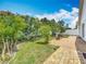 A spacious backyard featuring a brick patio, lush lawn, privacy fence and a grill at 1034 Copenhagen Way, Winter Garden, FL 34787