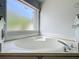 A bathroom featuring a relaxing soaking tub with a frosted window for privacy at 1034 Copenhagen Way, Winter Garden, FL 34787