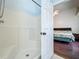 An ensuite bathroom with tiled shower and a doorway leading into the main bedroom at 1034 Copenhagen Way, Winter Garden, FL 34787