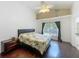 Well-lit bedroom with a ceiling fan, wood floors, and a window at 1034 Copenhagen Way, Winter Garden, FL 34787