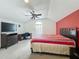 Bedroom with large window, desk and chair, ceiling fan, and a red accent wall at 1034 Copenhagen Way, Winter Garden, FL 34787