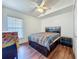 Bedroom with dark wood floors, ceiling fan and ample sunlight from window at 1034 Copenhagen Way, Winter Garden, FL 34787