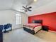 This bedroom features a red accent wall, desk, and ceiling fan at 1034 Copenhagen Way, Winter Garden, FL 34787