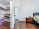 Open walk-in closet features storage shelves and leads to a bedroom with wood floors at 1034 Copenhagen Way, Winter Garden, FL 34787