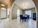 Formal dining room boasts arched doorway, neutral paint, ceramic tile flooring, and modern light fixture at 1034 Copenhagen Way, Winter Garden, FL 34787