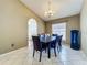Formal dining room boasts arched doorway, neutral paint, ceramic tile flooring, and modern light fixture at 1034 Copenhagen Way, Winter Garden, FL 34787