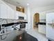 Bright kitchen featuring white cabinetry, black countertops and stainless steel appliances at 1034 Copenhagen Way, Winter Garden, FL 34787