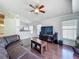 Spacious living room with a leather sofa, a wood coffee table, and a view of the kitchen at 1034 Copenhagen Way, Winter Garden, FL 34787