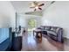 Bright living room with a vaulted ceiling, a ceiling fan, and sliding glass doors to the backyard at 1034 Copenhagen Way, Winter Garden, FL 34787