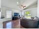 Open living room offers hardwood flooring, vaulted ceilings, ceiling fan and slider to back yard at 1034 Copenhagen Way, Winter Garden, FL 34787