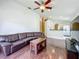 Open-concept living room with a leather sofa, wood floors, and a view of the kitchen at 1034 Copenhagen Way, Winter Garden, FL 34787