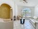 Bright living room features tile floors, a ceiling fan, neutral paint and a beautiful arched window at 1034 Copenhagen Way, Winter Garden, FL 34787