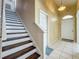 Home foyer featuring staircase, tile flooring, and a decorative golden accent wall at 1034 Copenhagen Way, Winter Garden, FL 34787