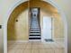 Welcoming home entrance with a grand staircase, neutral tile flooring, and an arched doorway at 1034 Copenhagen Way, Winter Garden, FL 34787