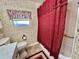 Standard bathroom with floral wallpaper, red shower curtain and window valance at 105 Avocado Cv, Leesburg, FL 34748
