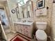 Bathroom featuring a single sink vanity, neutral flooring, and a decorative floral patterned wall at 105 Avocado Cv, Leesburg, FL 34748