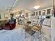 Open dining area with a glass table, upholstered chairs, and seamless flow to the living room and kitchen at 105 Avocado Cv, Leesburg, FL 34748
