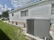 Single-story home with HVAC unit, well-maintained garden, and hardscape decor at 105 Avocado Cv, Leesburg, FL 34748