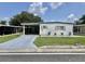 Charming single-story home with carport, well-maintained lawn, and beautiful landscaping at 105 Avocado Cv, Leesburg, FL 34748